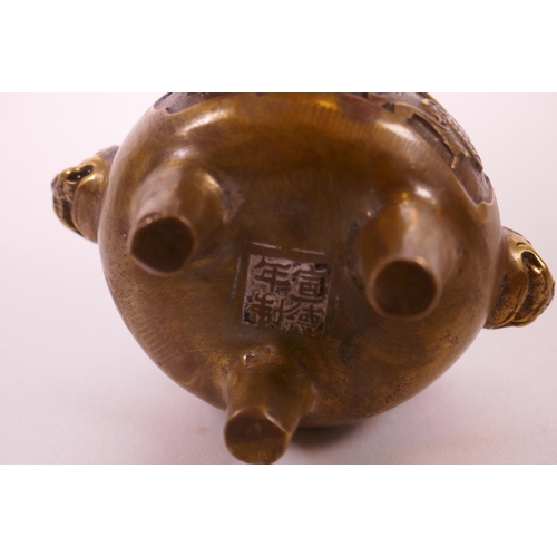 5 - A Chinese bronze censer raised on tripod feet with two kylin mask handles, decorated with stylised b... 