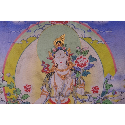 56 - A Tibetan machine embroidered silk thangka depicting a deity on a lotus throne, 15