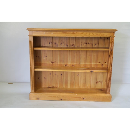 1233 - A pine open shelf bookcase, with reeded ends on plinth base, 42½