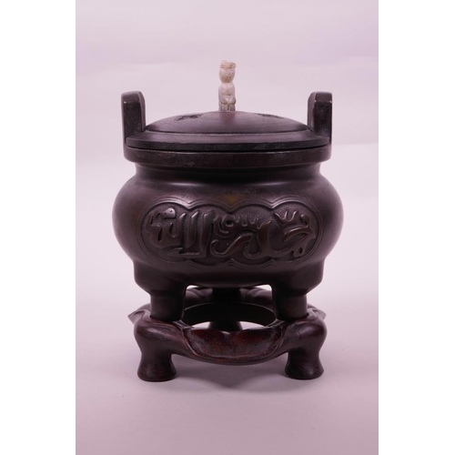 113 - A Chinese bronze censer on tripod supports with a carved hardwood stand and cover, calligraphy to si... 