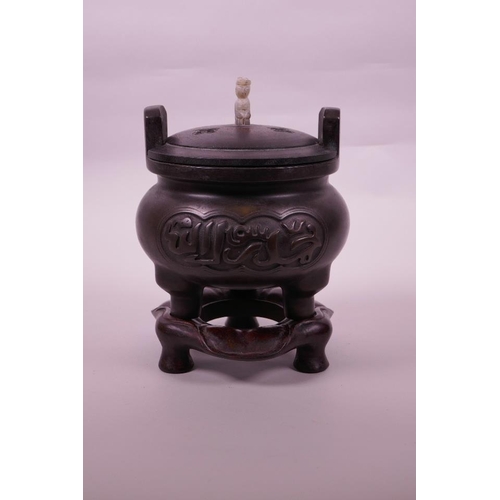 113 - A Chinese bronze censer on tripod supports with a carved hardwood stand and cover, calligraphy to si... 