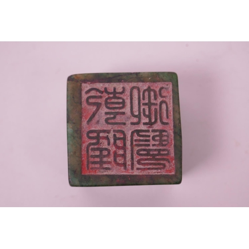 121 - A Chinese green hardstone seal with carved dragon and phoenix decoration to top, 2