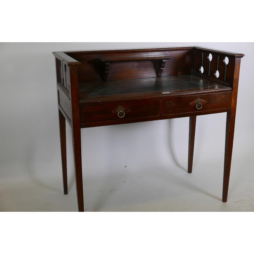 1220 - An Arts and Crafts mahogany writing table with galleried back, pierced ends and two frieze drawers, ... 