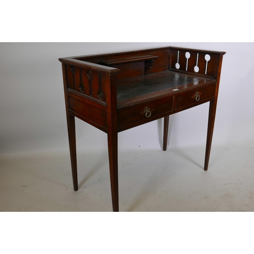 1220 - An Arts and Crafts mahogany writing table with galleried back, pierced ends and two frieze drawers, ... 