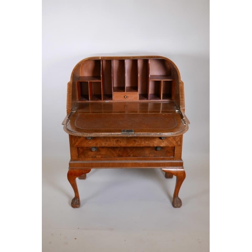 1225 - An Art Deco figured walnut bureau, with fall front over two drawers on cabriole supports with hairy ... 