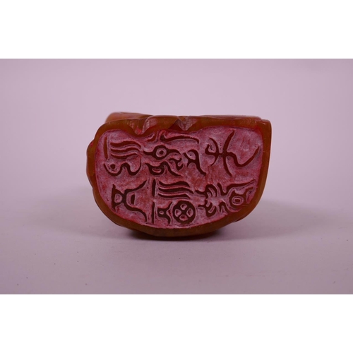 123 - A Chinese carved amber soapstone seal in the form of Buddha, 3½