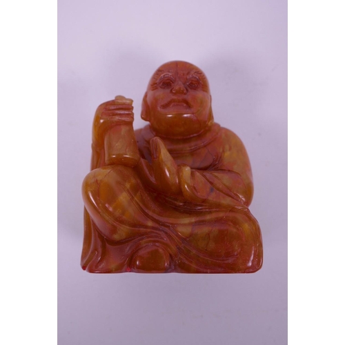 123 - A Chinese carved amber soapstone seal in the form of Buddha, 3½