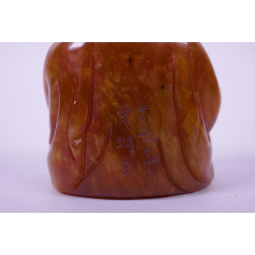 123 - A Chinese carved amber soapstone seal in the form of Buddha, 3½