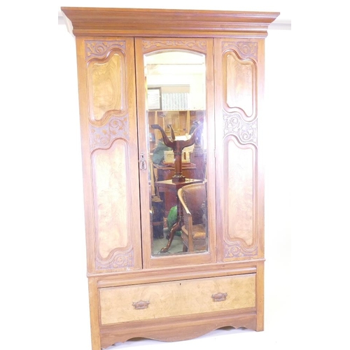 1232 - A late Victorian figured walnut mirror door wardrobe, with carved decoration, bears label Miller and... 