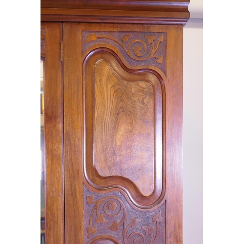 1232 - A late Victorian figured walnut mirror door wardrobe, with carved decoration, bears label Miller and... 