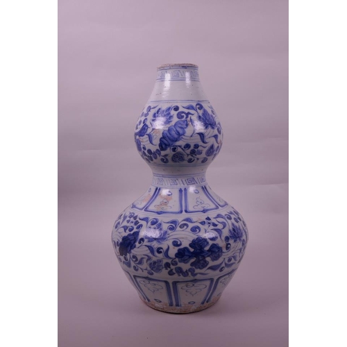 125 - A Chinese Ming style blue and white pottery double gourd vase with lotus flower decoration, 13½