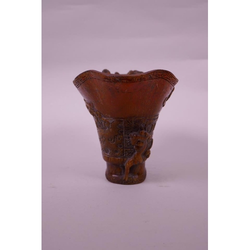 130 - A Chinese faux horn libation cup with carved kylin decoration, seal mark to base, 4½