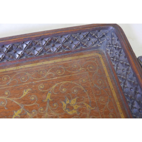 131 - An Anglo-Indian teak tray, with fine carved and brass inlaid decoration, 27