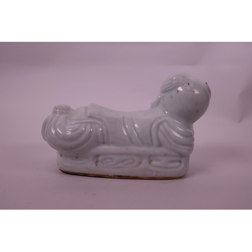 20 - A Chinese celadon glazed pottery pillow in the form of a child, impressed seal mark to base, 8½