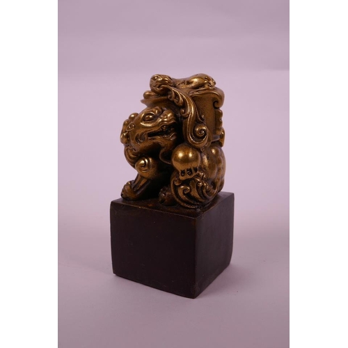 28 - A Chinese filled bronze square form seal with a gilt knop in the form of a dragon, 5