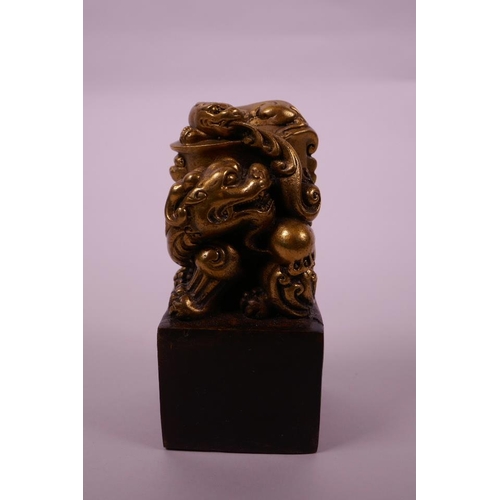 28 - A Chinese filled bronze square form seal with a gilt knop in the form of a dragon, 5