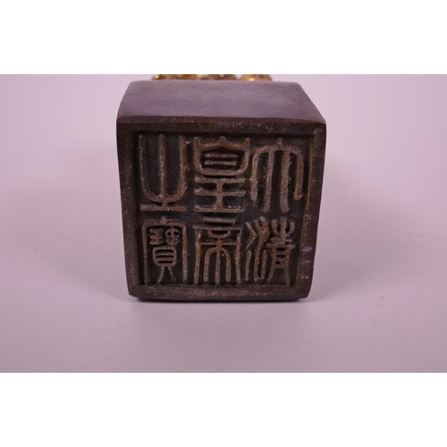 28 - A Chinese filled bronze square form seal with a gilt knop in the form of a dragon, 5