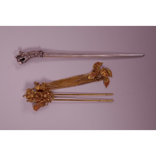 65 - A Chinese white metal hairpin with dragon head decoration to end, together with a gilt metal hairpin... 