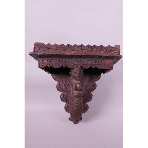 7 - An Asian carved wood wall bracket supported by a female figure, 13