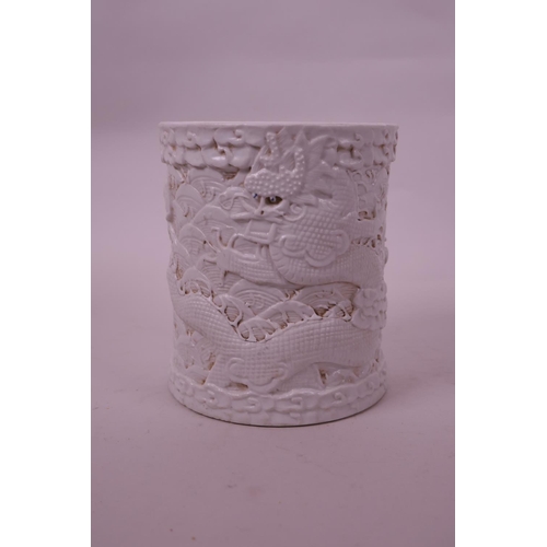 71 - A Chinese cream ground porcelain brush pot with raised  dragon decoration, impressed seal mark to ba... 