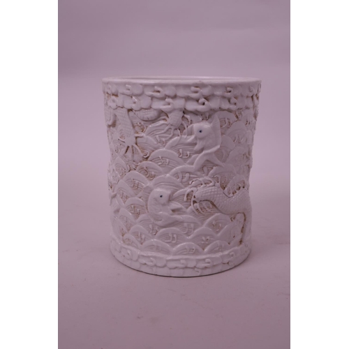 71 - A Chinese cream ground porcelain brush pot with raised  dragon decoration, impressed seal mark to ba... 