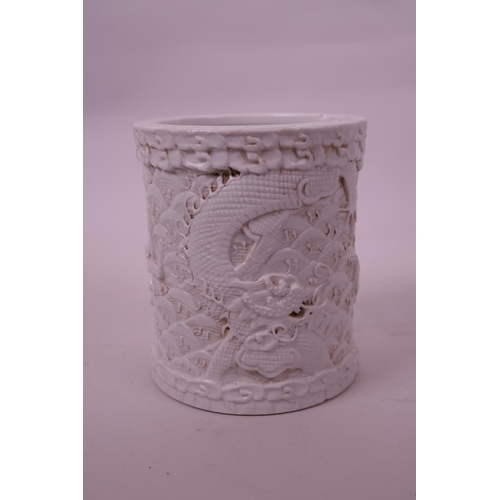 71 - A Chinese cream ground porcelain brush pot with raised  dragon decoration, impressed seal mark to ba... 