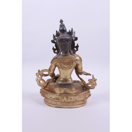 55 - A Sino-Tibetan gilt mixed metal Buddha seated on a lotus throne, holding a vajra and stupa, double v... 