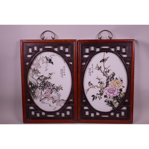 67 - A pair of Chinese polychrome porcelain panels depicting birds perched amongst branches in bloom, mou... 