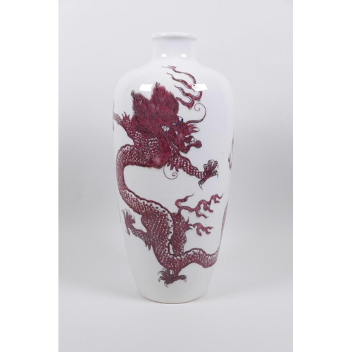 68 - A Chinese red and white porcelain vase decorated with dragons chasing the flaming pearl, two concent... 