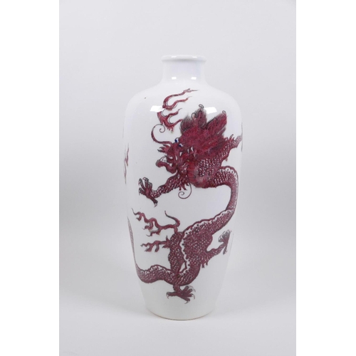 68 - A Chinese red and white porcelain vase decorated with dragons chasing the flaming pearl, two concent... 