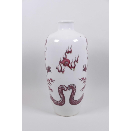 68 - A Chinese red and white porcelain vase decorated with dragons chasing the flaming pearl, two concent... 