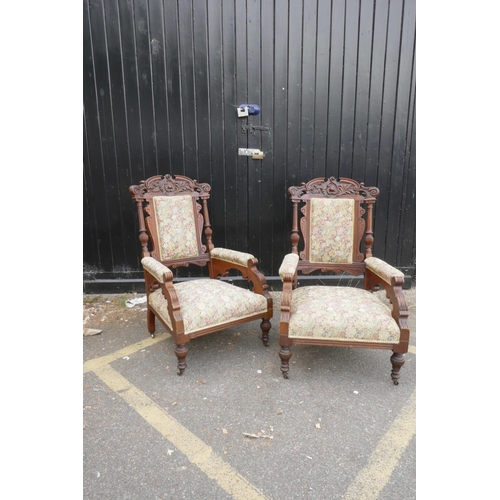 1207 - A pair of C19th walnut open armchairs with carved scroll and palm classical decoration, 44½