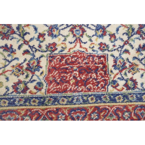 1205 - A large Persian pattern cream ground wool carpet, 143