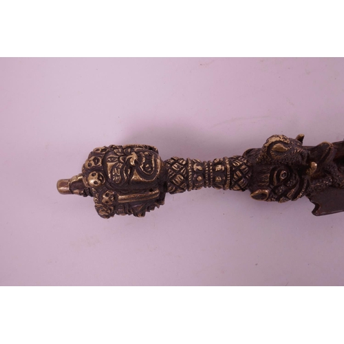 11 - A Sino-Tibetan bronzed metal ceremonial phurba, the handle decorated with a vajra, mythical creature... 