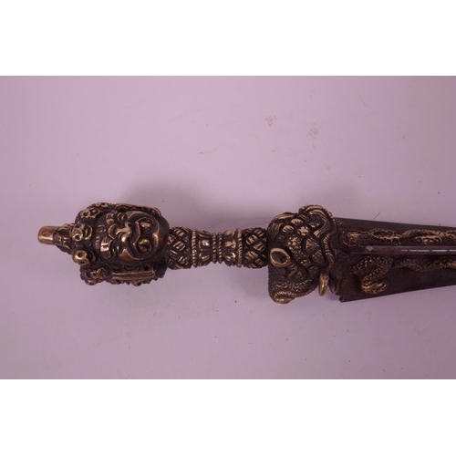 11 - A Sino-Tibetan bronzed metal ceremonial phurba, the handle decorated with a vajra, mythical creature... 