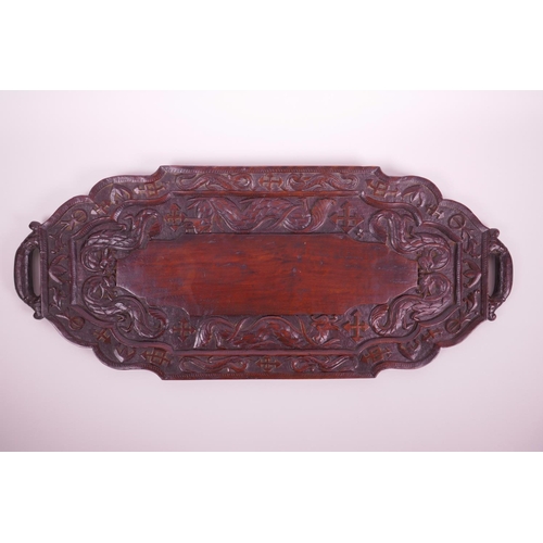 15 - An Oriental carved hardwood tray decorated with dragons and symbols, 24