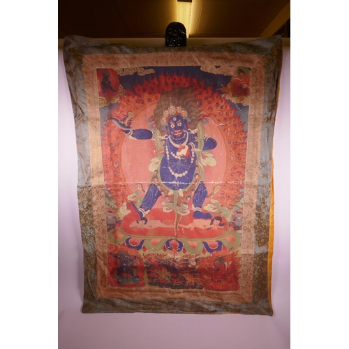 24 - A Sino-Tibetan printed thangka depicting a wrathful deity, with a silk surround, 30½