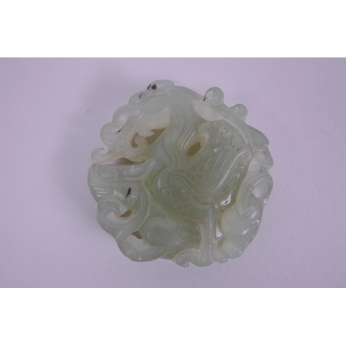 28 - A Chinese carved celadon hardstone pendant decorated with a dragon and phoenix, 2