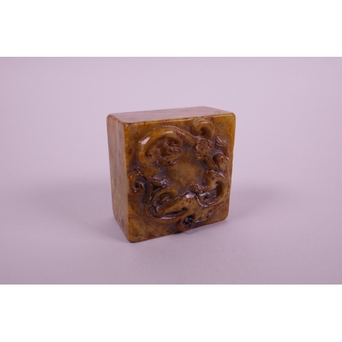 35 - A Chinese square form hardstone seal with carved dragon decoration to top, 2