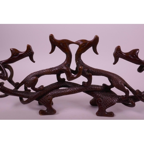 42 - A Chinese bronze brush rest in the form of entwined dragons, 13½