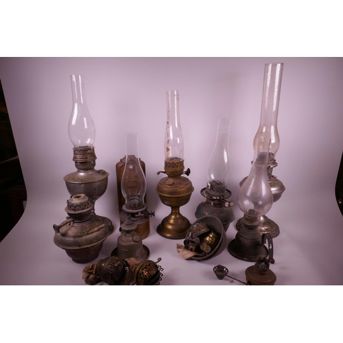 49 - A collection of assorted oil lamps, together with two boxes of spare glass chimneys and burners