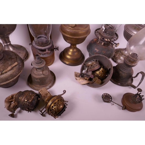 49 - A collection of assorted oil lamps, together with two boxes of spare glass chimneys and burners