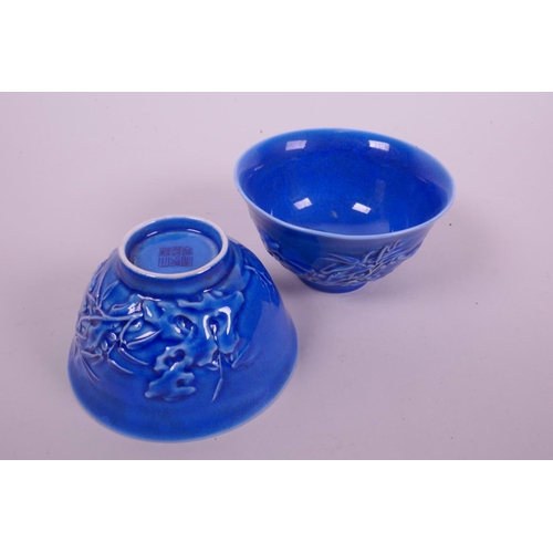 54 - A pair of Chinese blue glazed porcelain tea bowls with  bird and blossom decoration, seal mark to ba... 