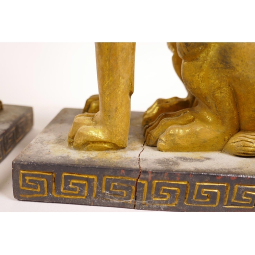 27 - A pair of gilt composition candlesticks of sphinx form, 12