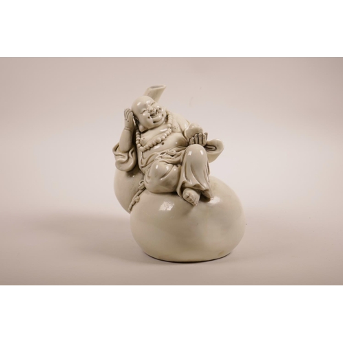 51 - A Chinese blanc de chine figure of Buddha reclining on a double gourd, impressed marks verso, 7