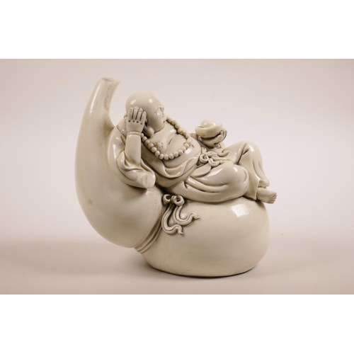 51 - A Chinese blanc de chine figure of Buddha reclining on a double gourd, impressed marks verso, 7