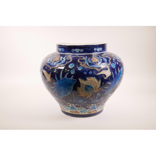 53 - A large Chinese blue ground pottery jardiniere with applied decoration of a lotus pond, 12