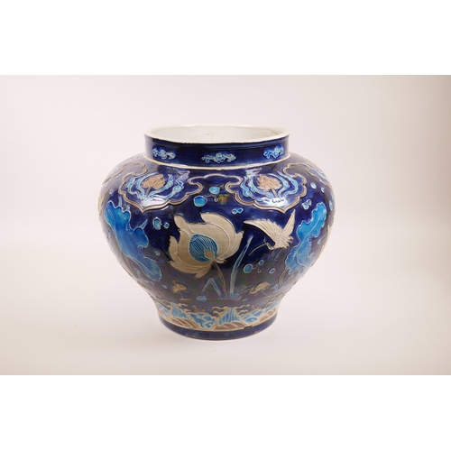 53 - A large Chinese blue ground pottery jardiniere with applied decoration of a lotus pond, 12