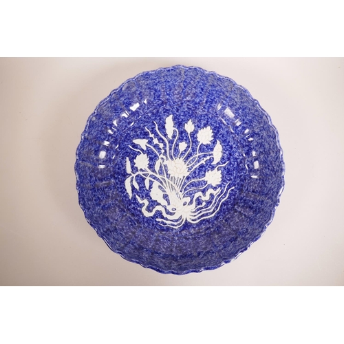 59 - A large Chinese blue and white pottery charger with a lobed rim and raised lotus flower decoration, ... 