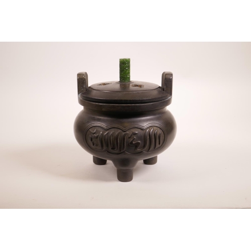 64 - A Chinese bronze censer on tripod feet with two handles, turned hardwood lid, carved green jade knop... 